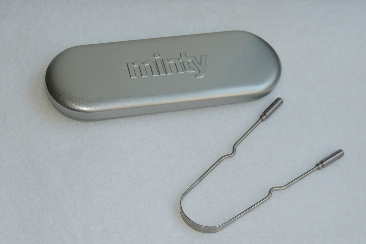 Metallic tool with a case labeled 'minity' on a light gray background